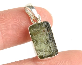 May include: Silver pendant featuring a raw green aventurine gemstone. The stone has a rough, natural texture and is set in a simple silver frame.