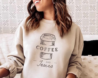 Peut inclure: Un sweat-shirt beige avec un graphique d'une tasse de café et le texte "COFFEE AND Jesus".