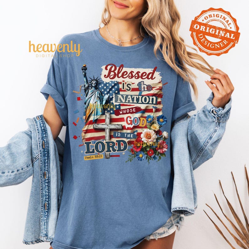 May include: A blue t-shirt with the text "Blessed is the Nation Whose God is the Lord", an American flag design, the Statue of Liberty, a cross, and floral accents. The shirt also has the text "heavenly DIGITAL SHOP" and "ORIGINAL DESIGNER".