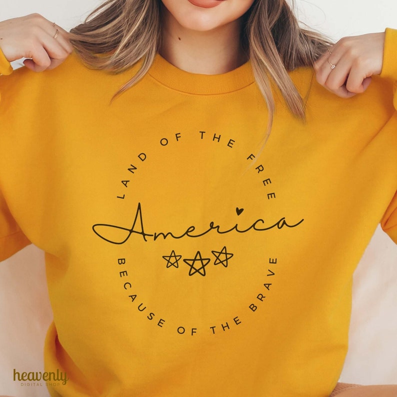 May include: Yellow sweatshirt with a black circle graphic that says "Land of the Free, America, Because of the Brave" with two stars and a heart.