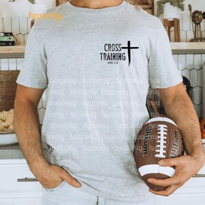Może przedstawiać: Szary T-shirt z czarnym krzyżem i napisem "CROSS TRAINING" z odniesieniem do Biblii "JOHN 3:16".