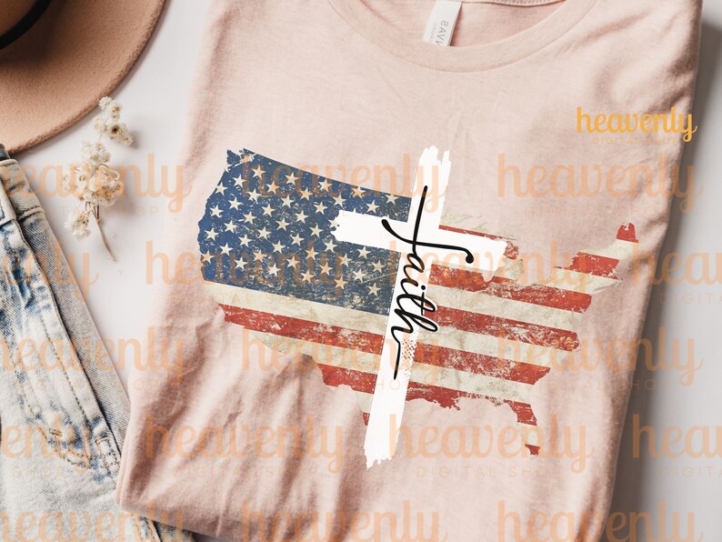 May include: A pink t-shirt featuring a distressed American flag design and a white cross with the word "Faith" written on it.