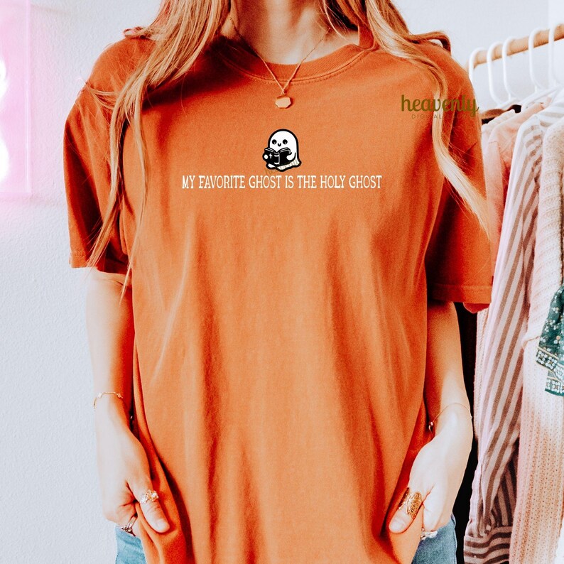 K&ouml;nnte beinhalten: Ein rostfarbenes T-Shirt mit einem wei&szlig;en Geistermotiv und dem Text "My favorite ghost is the Holy Ghost".