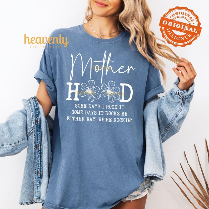 May include: A blue t-shirt with the text "Mother Hood" in white with a floral design and the text "Some days I rock it, some days it rocks me, either way, we're rockin'" in white.
