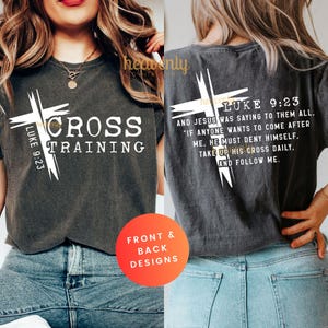 May include: Dark gray t-shirt with white text and cross graphics. The front of the shirt reads "CROSS TRAINING" with "LUKE 9:23" on the cross. The back of the shirt has a cross graphic and a Bible verse from Luke 9:23.