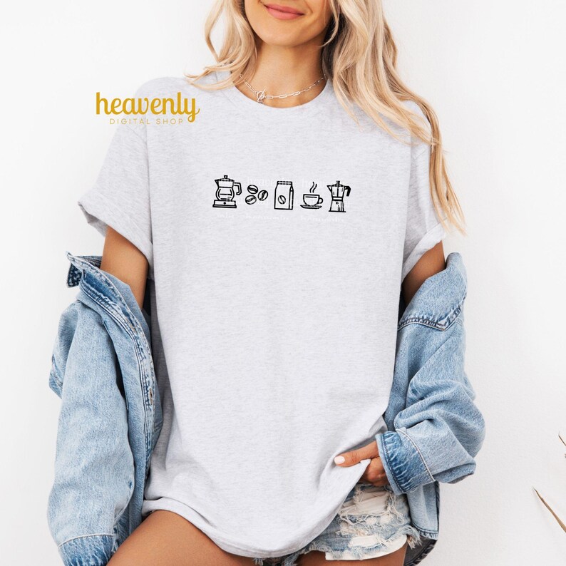 May include: A gray t-shirt with a black graphic of coffee icons, including a coffee pot, coffee beans, a bag of coffee, a cup of coffee, and a coffee maker.