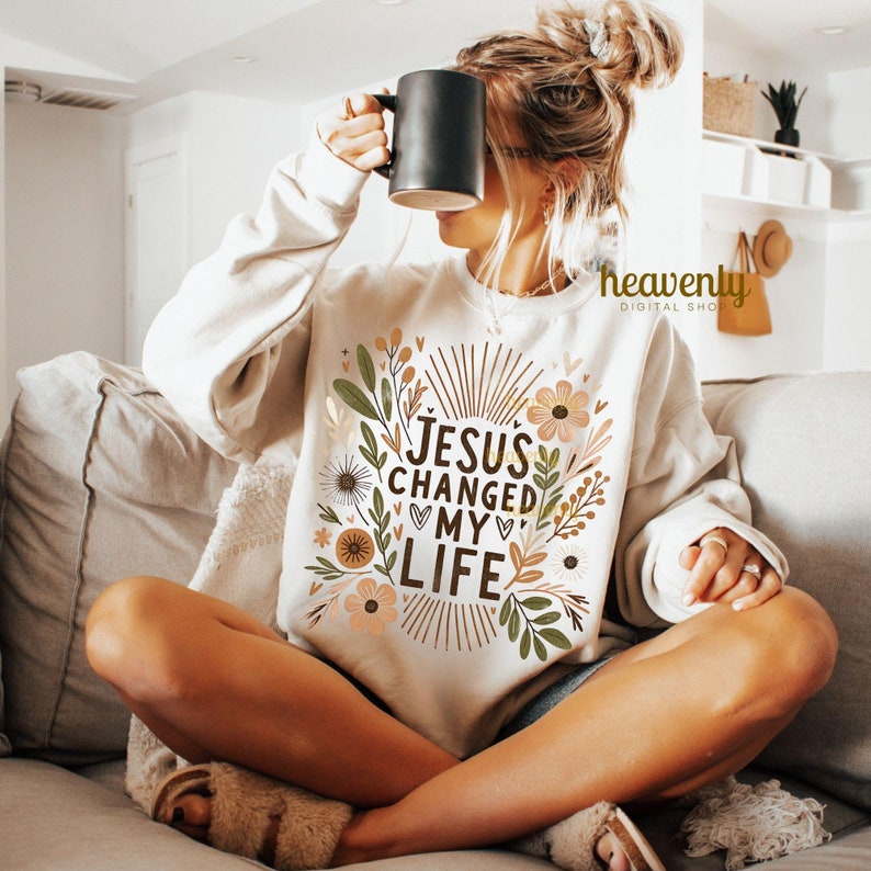 May include: A white sweatshirt with a floral design and the text "JESUS CHANGED MY LIFE".