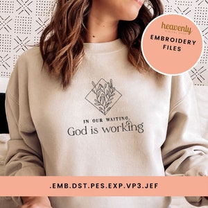 May include: A beige sweatshirt with the text "In our waiting, God is working" and a small floral design in a diamond shape. The text "heavenly digital shop" and "Embroidery Files" are in a peach-colored circle at the top right corner of the image. The text ".emb.dst.pes.exp.vp3.jef" is at the bottom of the image.