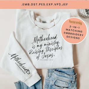 May include: White sweatshirt with the text "Motherhood is my ministry. Raising Disciples of Jesus. Proverbs 22:14" on the front and "Motherhood is Kingdom Work" on the sleeve. The sweatshirt is paired with blue jeans.