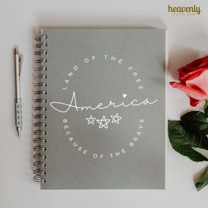 May include: Gray spiral bound notebook with a white circle design that says "Land of the Free, America, Because of the Brave".