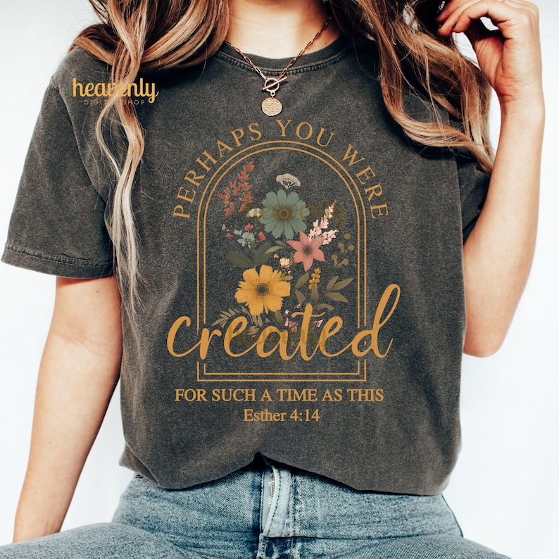 K&ouml;nnte beinhalten: Ein dunkelgraues T-Shirt mit einem Blumendesign und dem Text "Perhaps you were created for such a time as this Esther 4:14".