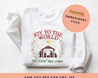 May include: White sweatshirt with red and green embroidery of a nativity scene with the text "Joy to the World" and "The Lord Has Come".