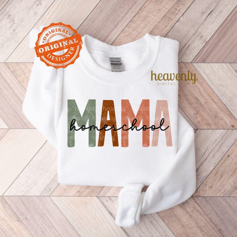 Puede incluir: Sudadera blanca con el texto "MAMA homeschool" en una fuente colorida y en capas. El texto est&aacute; en tonos de verde, naranja y rosa.