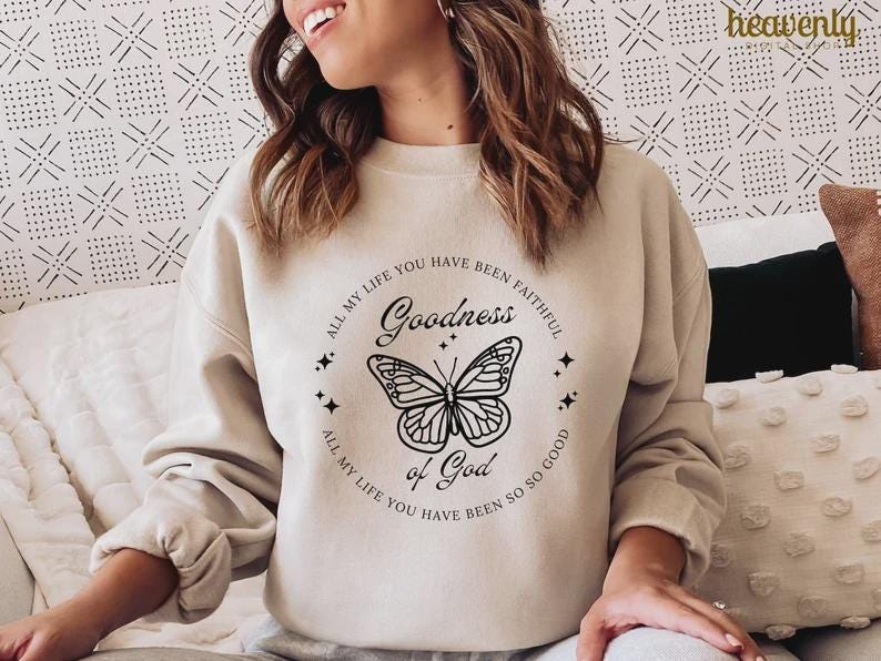 Pu&ograve; includere: Felpa beige con grafica circolare raffigurante una farfalla e le parole "Goodness of God". &Egrave; incluso anche il testo "All my life you have been faithful" e "All my life you have been so so good". La parola "heavenly" si trova nell'angolo in alto a destra.