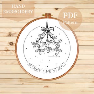 May include: A hand embroidery PDF pattern featuring a mistletoe design with a bow, berries, and the words "Merry Christmas" in a wooden embroidery hoop. The text "Hand Embroidery" and "PDF Pattern" are also visible.