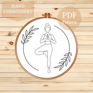 May include: A black and white line drawing of a person in a yoga pose, with leaves on either side. The image is in a hoop and says "PDF Pattern" at the top.