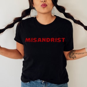 May include: Black t-shirt with the word "MISANDRIST" printed in red on the front.