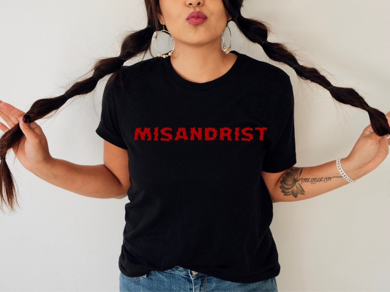 May include: Black t-shirt with the word "MISANDRIST" printed in red on the front.