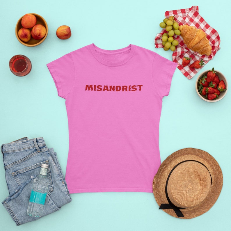 May include: Pink women's t-shirt with the word "MISANDRIST" printed in red on the front.