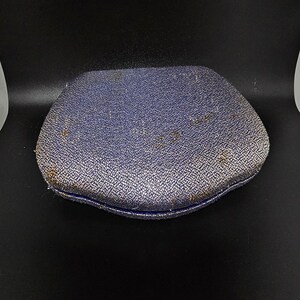 May include: A blue velvet jewelry box with a slightly rounded top and a textured surface.