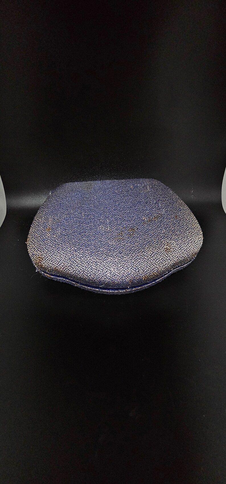 May include: A blue velvet jewelry box with a slightly rounded top and a textured surface.