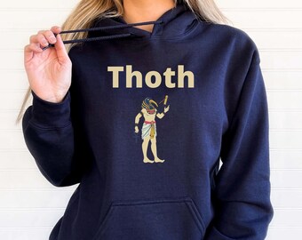 May include: Navy blue hoodie with the word "Thoth" in a light tan font. Below the text is a graphic of an Egyptian figure. The figure is tan with a blue and gold headdress, holding a staff.