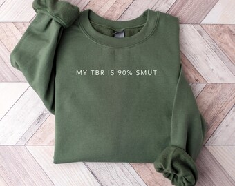 May include: A dark green sweatshirt with the text "MY TBR IS 90% SMUT" printed in white on the front.