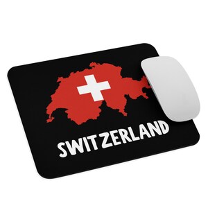 May include: A black mouse pad with a red outline of Switzerland and a white Swiss cross. The text "SWITZERLAND" is printed in white below the outline.