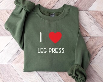 May include: Green sweatshirt with a white graphic that says "I love leg press" with a red heart.