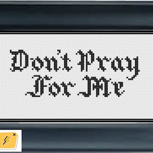 May include: Cross-stitch pattern with black text on a white background that reads "Don't Pray For Me".