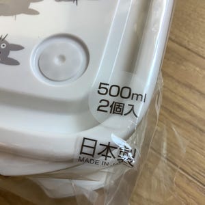 May include: White plastic food container with a lid, featuring gray cartoon characters. The container has a capacity of 500ml and is labeled "Made in Japan".