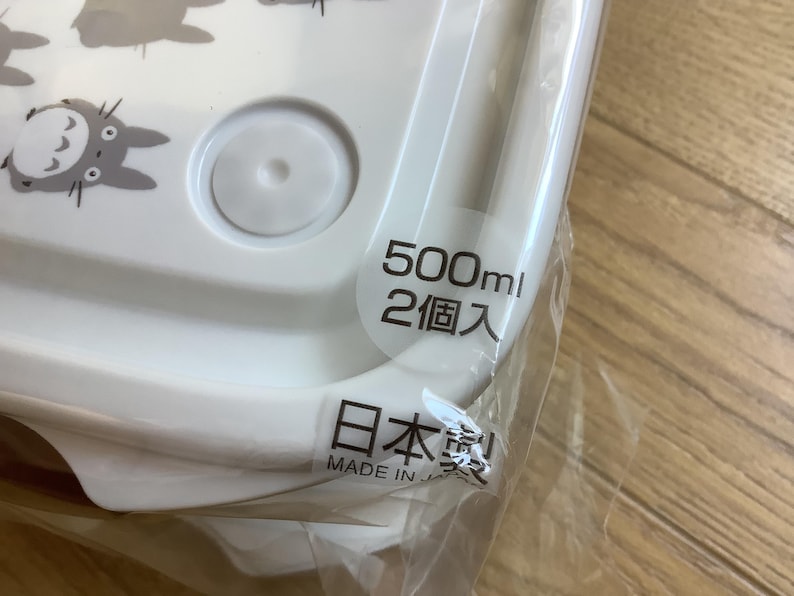 May include: White plastic food container with a lid, featuring gray cartoon characters. The container has a capacity of 500ml and is labeled "Made in Japan".
