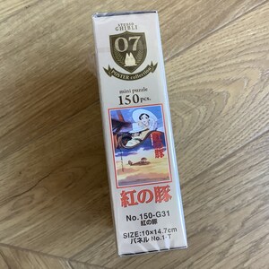 May include: A mini puzzle box from the Studio Ghibli Poster Collection. The box features a colorful illustration from the movie "Porco Rosso" and includes 150 pieces. The box dimensions are 10 x 14.7 cm.