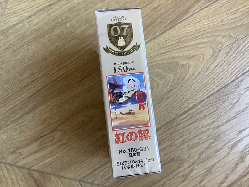 May include: A mini puzzle box from the Studio Ghibli Poster Collection. The box features a colorful illustration from the movie "Porco Rosso" and includes 150 pieces. The box dimensions are 10 x 14.7 cm.