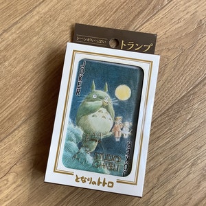 May include: A deck of playing cards featuring a Studio Ghibli illustration of Totoro. The card shows Totoro standing in front of a moon, with the word "Joker" on the side. The packaging has Japanese text.