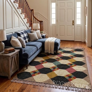 Pu&ograve; includere: Soggiorno con divano blu, cuscini e coperta con frange. Un tappeto geometrico con forme nere, beige, rosse e gialle &egrave; sul pavimento in legno. Tavolini in legno e lampade completano l'atmosfera calda. Il tappeto misura circa 244 cm x 305 cm.