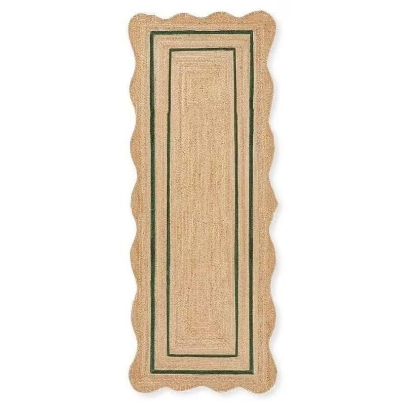 May include: A rectangular jute rug with a scalloped edge. The rug has a natural tan color with a dark green border. The inner rectangle has a similar dark green border. This rug is suitable for a hallway or entryway.