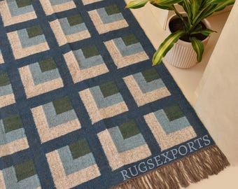 May include: A rectangular area rug featuring a repeating geometric pattern of squares in shades of dark blue, light blue, and dark green, with a textured beige background. The rug includes a fringe border and the text RUGSEXPORTS in the corner.