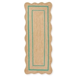 May include: A rectangular jute rug with a scalloped edge and a teal border. The rug has a natural, woven texture and a rectangular teal border. The rug is designed for indoor use and adds a touch of coastal style to any room.