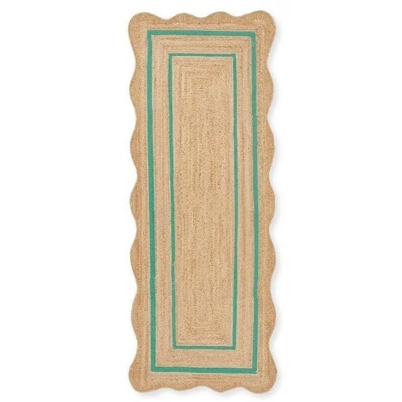 May include: A rectangular jute rug with a scalloped edge and a teal border. The rug has a natural, woven texture and a rectangular teal border. The rug is designed for indoor use and adds a touch of coastal style to any room.