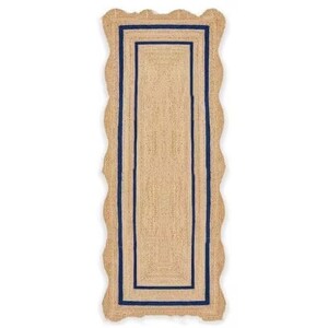 May include: A rectangular jute runner rug with a scalloped edge. The rug features a natural tan color with a navy blue border and a rectangular navy blue inner design. The rug is designed for indoor use.