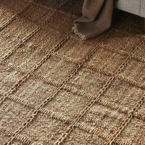 May include: A natural fiber rug with a woven diamond pattern in a light brown color.