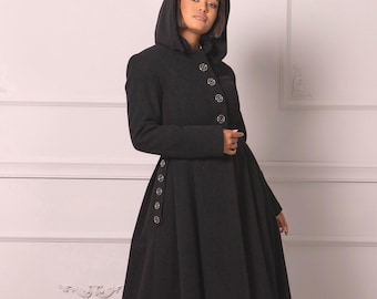 May include: A floor-length black coat featuring a hood, long sleeves, and a fitted bodice that flares into a full skirt. The garment is secured with a vertical row of circular silver buttons down the front and additional buttons along the side.