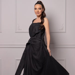May include: A black sleeveless maxi dress with a wrap-style bodice and a flowing skirt. The dress is tied at the waist with a matching sash.