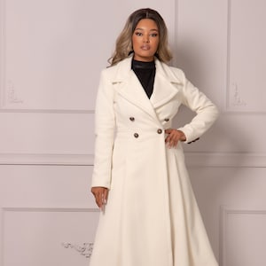 May include: A white double-breasted coat with a flared skirt and brown buttons.