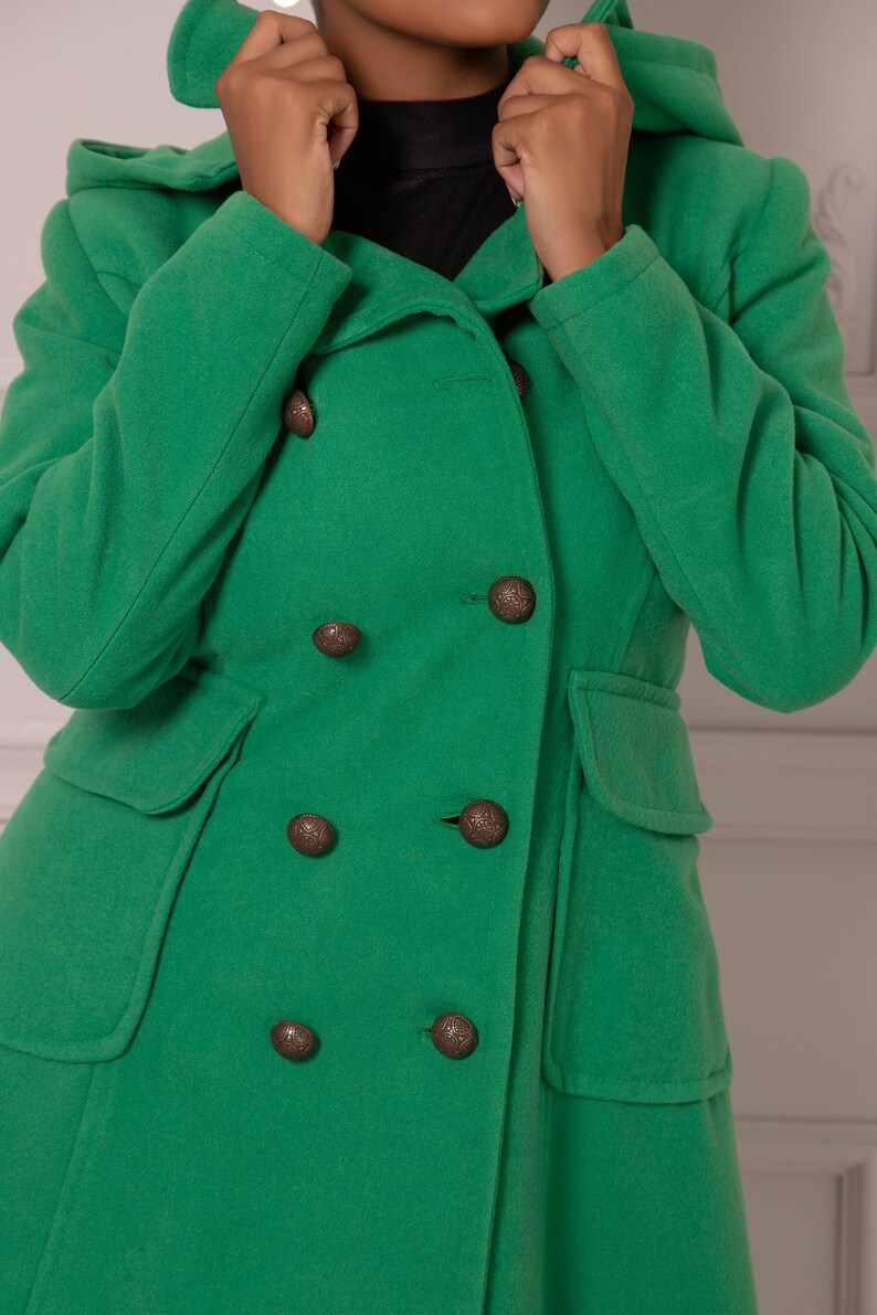 May include: A green hooded double-breasted coat with six large brown buttons.