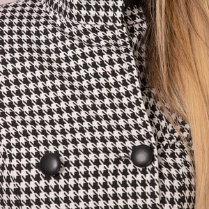 May include: Black and white houndstooth pattern jacket with a high collar and black buttons.