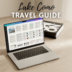 Peut inclure: Un ordinateur portable affichant un guide de voyage numérique pour le lac de Côme, en Italie. Le guide comprend du texte, des images et des cartes. L'ordinateur portable est sur une table en bois avec un livre noir.