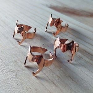 Peut inclure: Quatre bagues en cuivre avec un motif g&eacute;om&eacute;trique. Les bagues ont toutes le m&ecirc;me design, mais sont de tailles diff&eacute;rentes.