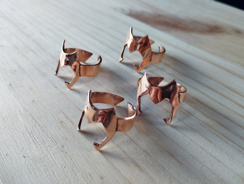 Peut inclure: Quatre bagues en cuivre avec un motif g&eacute;om&eacute;trique. Les bagues ont toutes le m&ecirc;me design, mais sont de tailles diff&eacute;rentes.